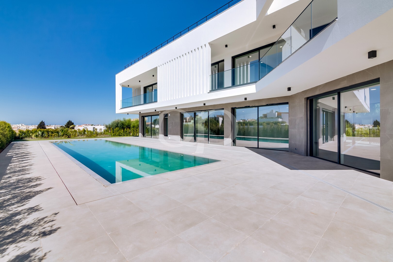 Extérieur d'une villa contemporaine avec piscine privée et grande terrasse ensoleillée