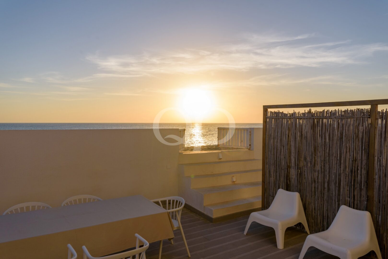 Vistas luxuosas do pôr-do-sol na praia a partir de um espaçoso terraço privado à beira-mar