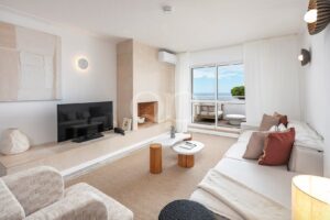 Sitting room with fireplace, television and doors opening onto the balcony