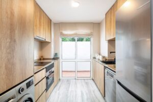 Fully fitted kitchen with wood cabinetry and access to outdoor terrace