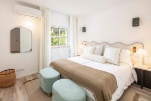 Bright bedroom with seating area and soft neutral finishes