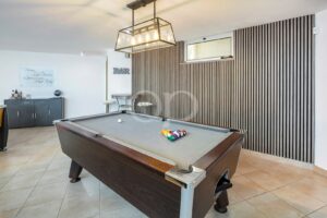Spielzimmer mit Billardtisch und stilvollem, modernem Barbereich