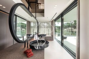 Casa de banho com janelas do chão ao teto e lavatório duplo