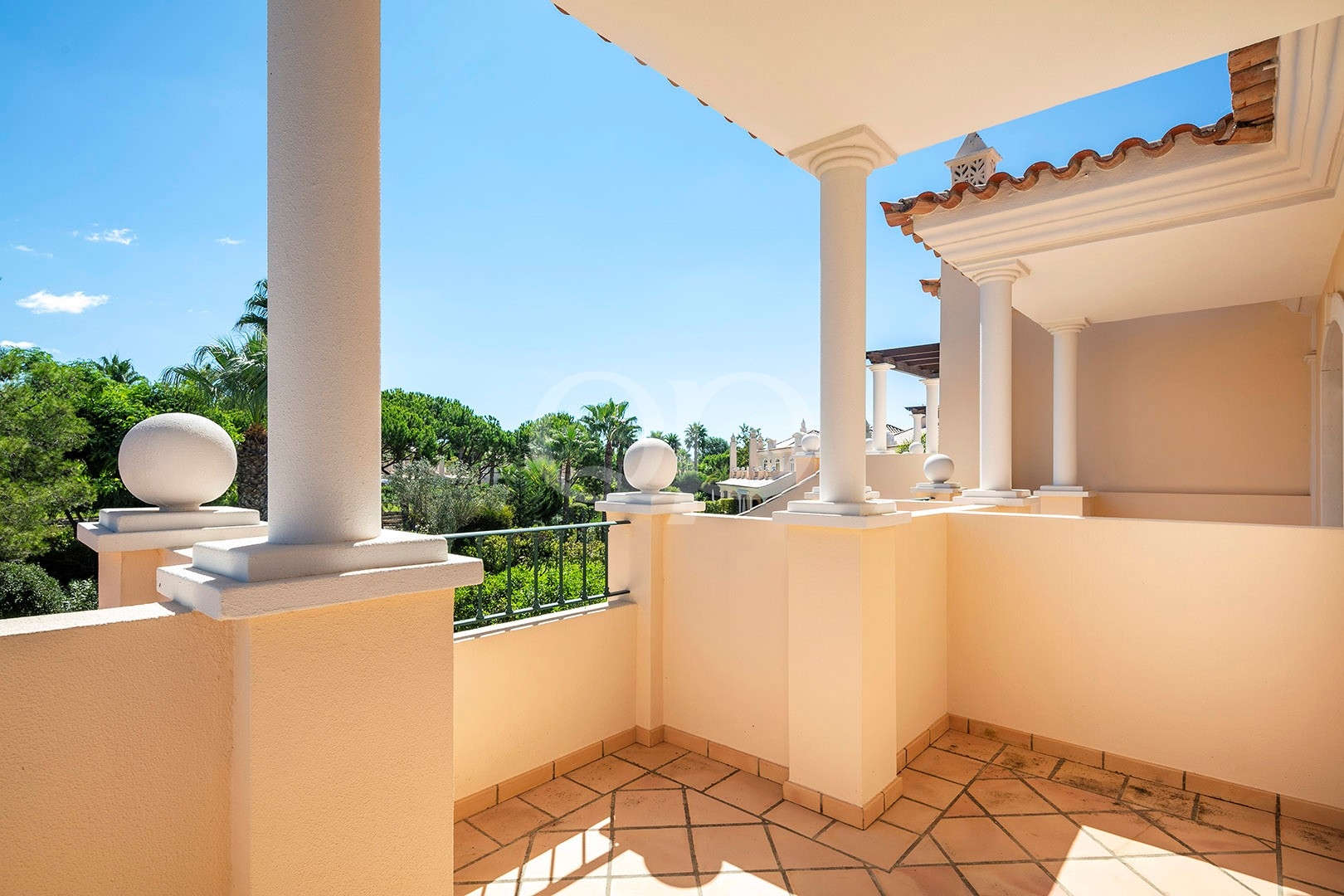 Sunny balcony overlooking landscaped surroundings