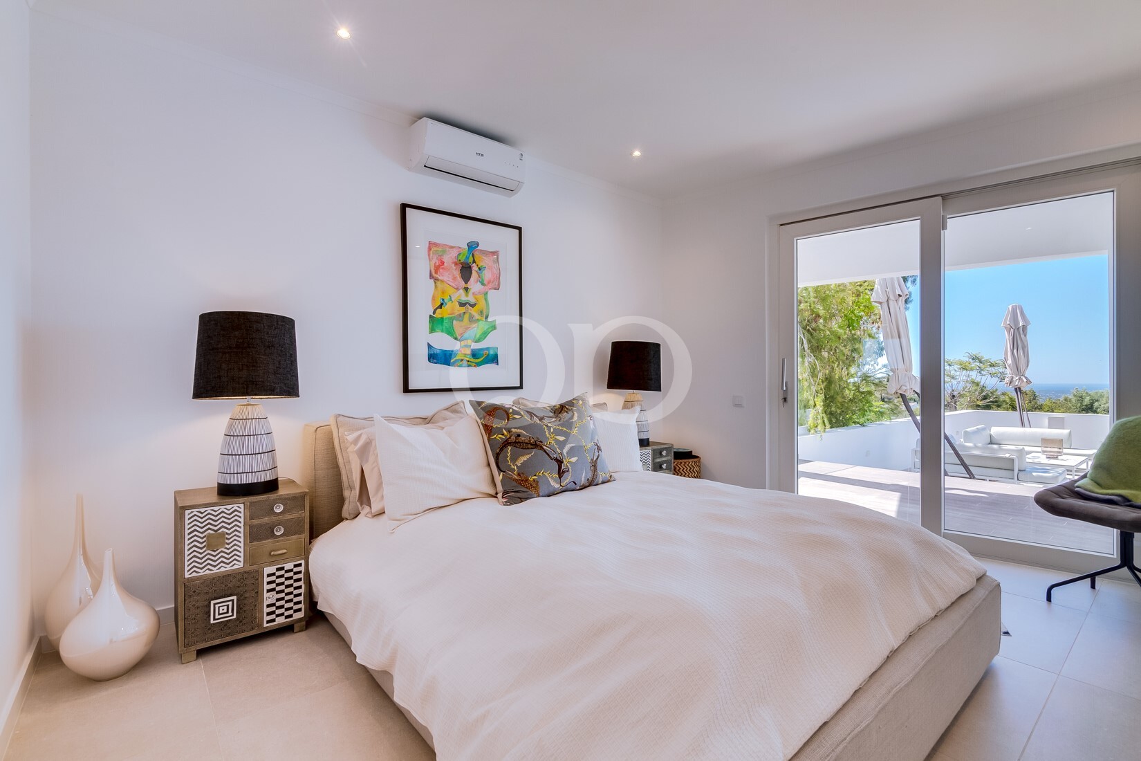 Chambre lumineuse donnant accès à une terrasse avec vue sur le paysage environnant