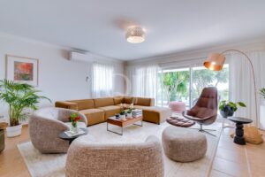 Salon lumineux doté d'un coin salon confortable et de grandes baies vitrées donnant sur le jardin