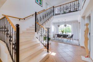 Hall d'entrée lumineux avec un escalier élégant et un coin repas attenant