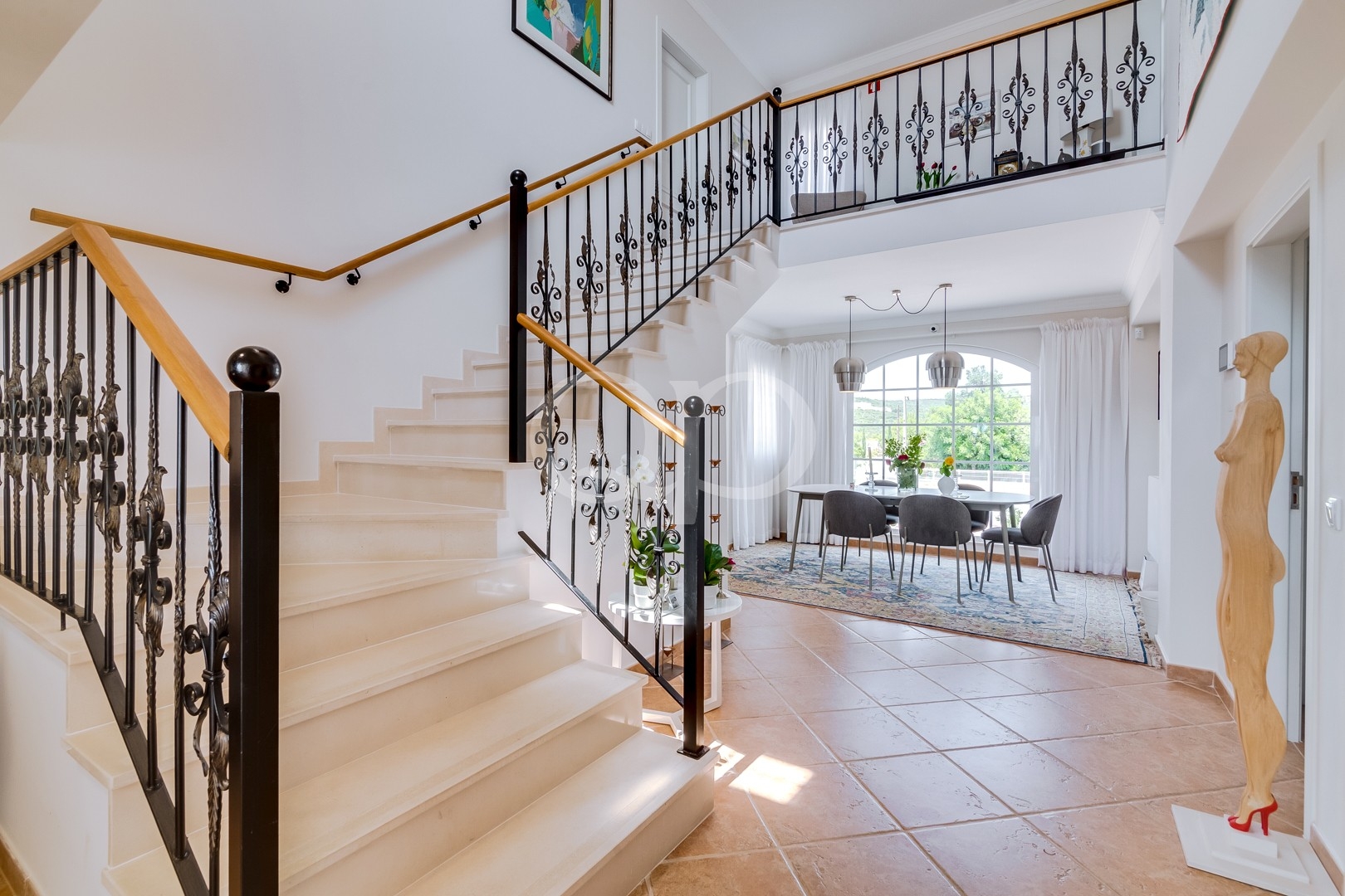 Hall d'entrée lumineux avec un escalier élégant et un coin repas attenant