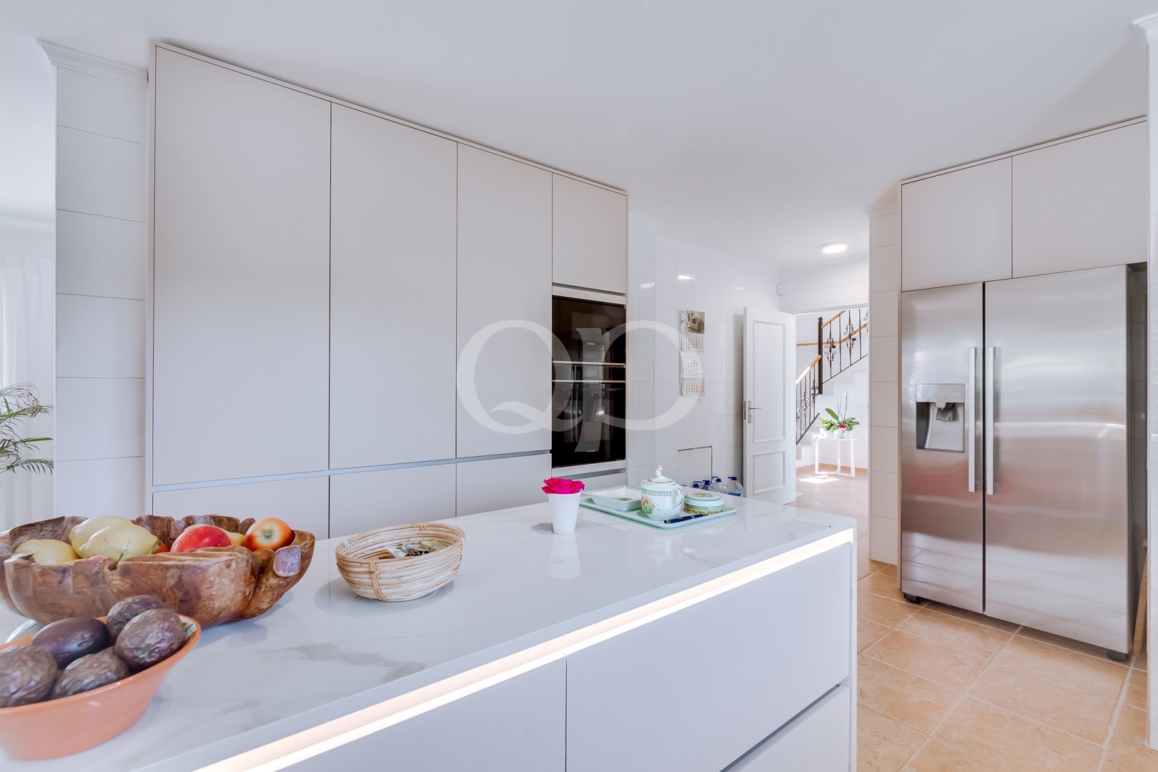 Cuisine équipée contemporaine avec îlot et mobilier blanc aux lignes épurées