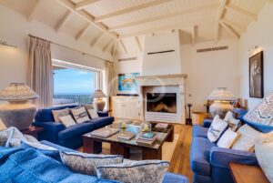 Espaço de estar elegante e espaçoso, com uma lareira luxuosa e um terraço com vistas panorâmicas sobre o mar