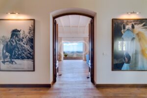 Entrada elegante em arco, com piso de madeira, que conduz a vistas panorâmicas sobre uma vegetação exuberante