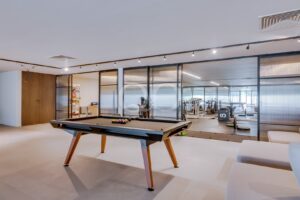 Espace de loisirs avec table de billard et salle de sport à domicile attenante entièrement équipée