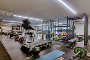 Salle de sport privée à domicile équipée d'appareils de cardio, d'haltères et d'un espace d'entraînement