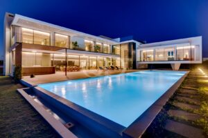 Piscine éclairée et villa contemporaine de Vilamoura la nuit