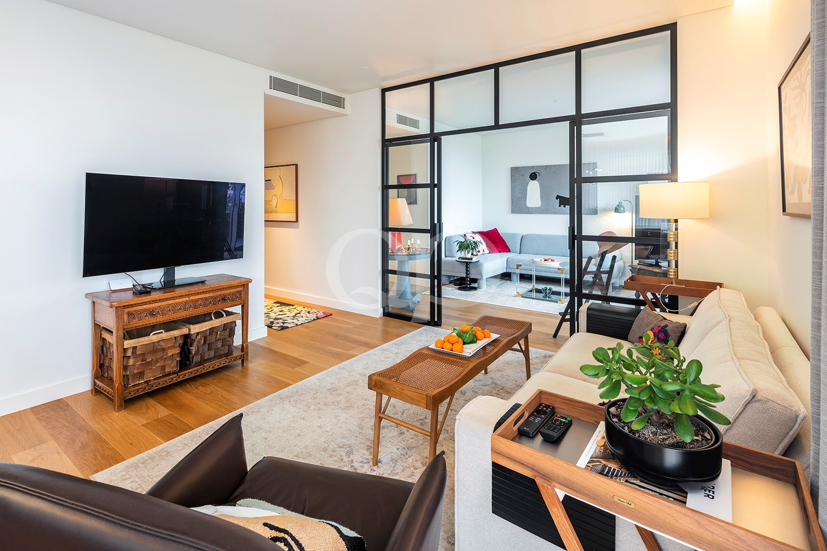 Bright sitting room with modern glass partition and wooden flooring