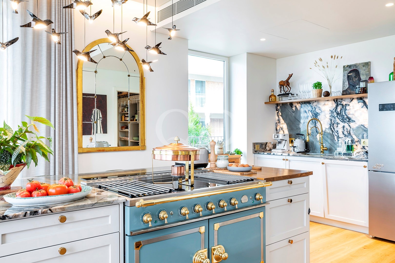 Stylish fitted kitchen with colourful island and elegant decorative details