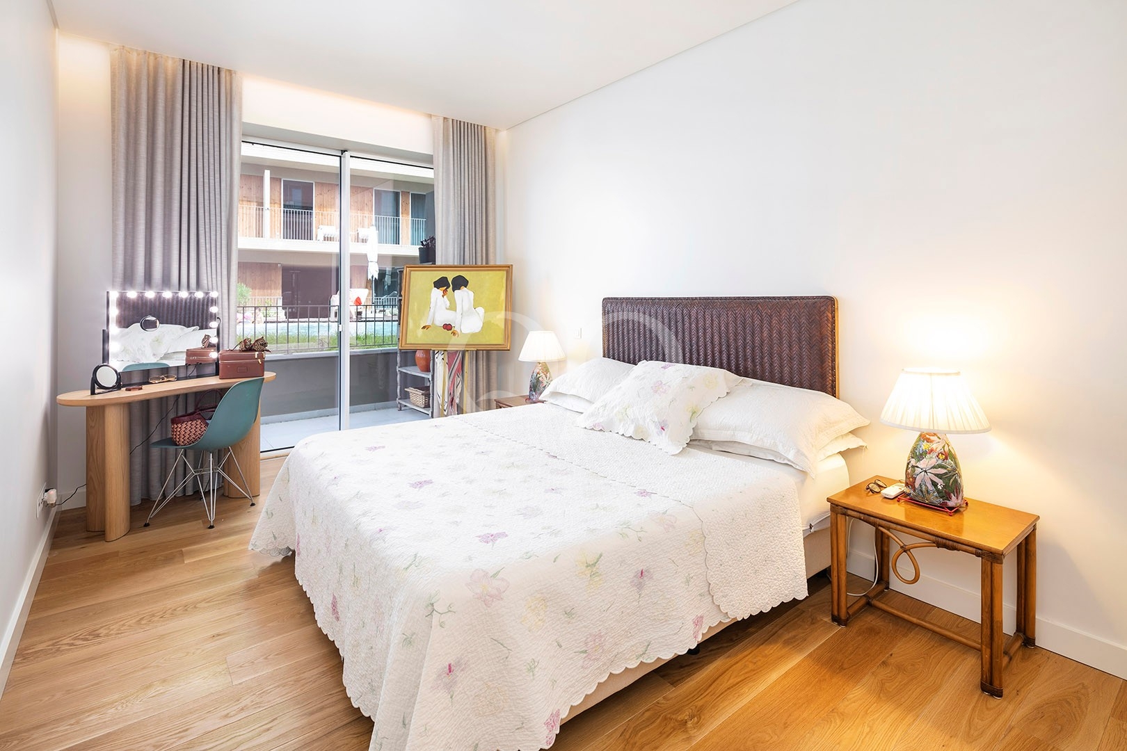 Bright bedroom with balcony access and comfortable neutral furnishings