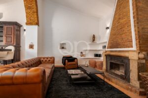 Cosy living room with leather sofas, fireplace and exposed brick ceiling