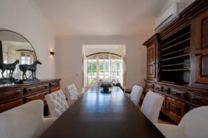 Elegant dining room with wooden dining table and views of the estate grounds