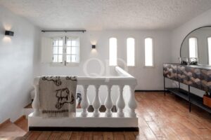 Bright upper-floor landing with white balustrades and natural wooden flooring