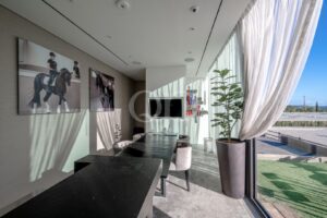 Contemporary dining area with floor-to-ceiling windows overlooking the landscaped grounds